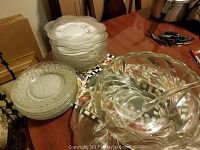 Photo showing the punch bowl, ladle inside it, and to the side a stack of plates and decorative platter underneath the punch bowl set.