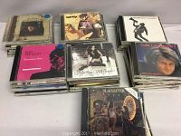 Lot of over 40 mixed genre music CDs in jewel cases stacked together, visible titles include Martina McBride, Tom Cochrane, Rod Stewart.