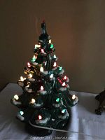 Front view of the vintage ceramic Christmas tree lit up showing multi-colored bulbs.