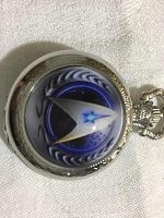 Close-up of the front cover of the pocket watch showing the Star Trek emblem in blue and silver tones.