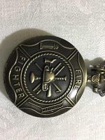 Closed front cover view showing embossed firefighter badge design with crossed axe and nozzle details.