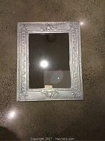 Full view of rectangular metal framed mirror on polished concrete floor, showing size and overall condition.