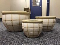 Three ceramic nesting planters arranged from largest to smallest, displaying the beige and cream checkered pattern and rounded rims.