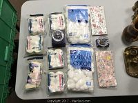 Overview of all items on table including cotton sponges, two floral cases, crystal ring holder, and rosette ring.