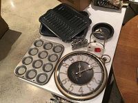 View of the complete lot on a table including baking trays, wall clock, and napkin holders