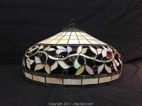 Front side view of the stained glass chandelier showing the vine leaf and jewel accents.