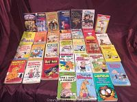 Photo of vintage comic books arranged in rows showing titles Hardy Boys, Happy Days, Snoopy, Eggheads, Marmaduke, Charlie Brown, Dennis the Menace, Beetle Bailey, Garfield, Batman, and Heathcliff.