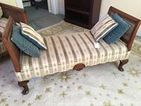 Angled view of the hall bench showing striped fabric upholstery, cane side panel, carved wooden detailing, and attached cushions.