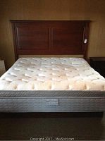 Full view of king size bed including wooden headboard, plush mattress, and bed frame.