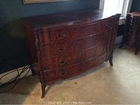 Front view of serpentine front dresser showing four drawers and overall condition