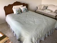 Full view of queen size bed setup with the wooden Thomasville headboard, mattress, box springs, and bedding with pillows.