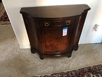 Front view of the chest showing curved front edges, top drawer with handles, and single cabinet door with wood grain finish.