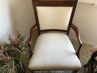 Full view of the chair showing wood frame and white textured upholstery.