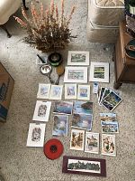 Overview photo showing art prints, postcards, vintage records, brass jewelry box, mirror, and brush laid out on carpet.
