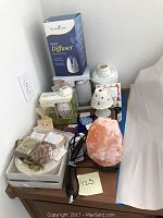 Photo showing Himalayan salt lamp, diffusers in boxes, and heart-shaped stones.