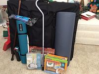 Full lot view showing massage table in bag, Pilates mat, canes, reflexology kits, sound machine and foam roller