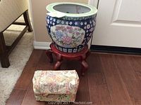 Large Asian ceramic flower pot on wooden stand with two floral fabric doorstops in front