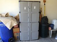 Front view of Rubbermaid plastic storage cabinet showing four doors and handles, set in a garage.
