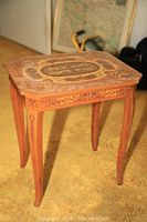 Full view of music box end table with inlay on wooden legs and top.