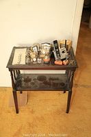 Full view of dark wood phone table with all items on top and lower shelf empty