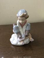 Seated boy on sled figurine on tabletop