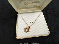 Close-up of gold-filled Star of David necklace displayed in Bernadette branded box