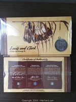 Overhead view of sealed US Mint Lewis and Clark packaging showing front cover artwork and certificate