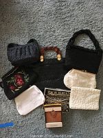 Overview of assorted handbags, pouches and tote on carpet