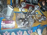 Five-arm silver candelabra placed on glass platter with small pitchers and spice set around