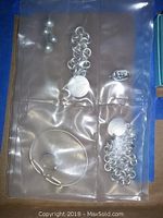 Overall group shot showing chain bracelet, bangle, cufflinks and pendant in clear pouch