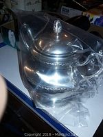 Overall view of sterling silver sugar bowl with lid wrapped in protective plastic