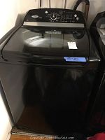 Front view of black Whirlpool Cabrio top-load washing machine showing transparent lid and control panel