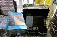 Side view of box of envelopes and Sony flash case on a metal rolling cart