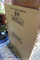 Photo of the dishwasher boxed showing front and handling icons.