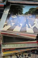Stack of Beatles vinyl records with Abbey Road on top
