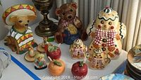 Display of Chihuahua cookie jar with sombrero, teddy bear cookie jar, gingerbread man cookie jars, and Mexican-themed salt and pepper shakers.