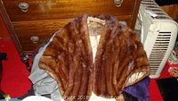 Brown ladies mink stole draped showing satin lining with wear