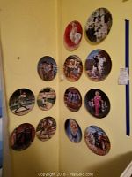 A group of twelve decorative collectible plates mounted on a wall, featuring Marilyn Monroe and scenes from classic western films with cowboys and horses.