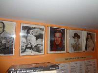 Wide shot showing five plastic framed celebrity photos mounted on wall, including Bob Hope, Rhonda Fleming, Charlton Heston, Joel McCrea, and Jane Russell.