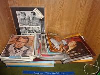 Shelf display of loose photos, magazines and binder