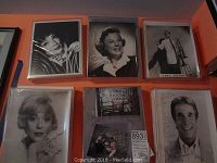 Overview of six autographed celebrity photos including Henry Winkler, Edie Adams, James Stewart, and others, all framed in plastic sleeves.
