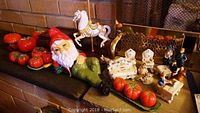 Shows the nine Occupied Japan Victorian era dressed figurines, Royal Doulton dog figurine, tomato salt and pepper sets, condiment set, creamer, and part of the winter music box.