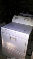 Full view of Kenmore white electric dryer showing front, door closed with control knobs on top panel.