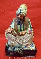 Front view of The Cobbler figurine showing man seated holding shoe