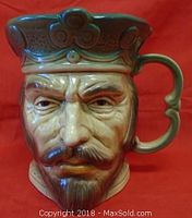 Front view of Edward I Toby Jug showcasing detailed facial features and crown, red background.
