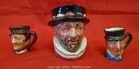 Front view of 3 mini Toby jugs with detailed facial features and hats.