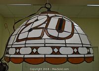Side view of dome-shaped stained glass lamp showing number 20 on white and amber glass background