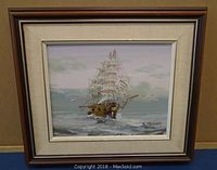 Framed oil painting of a sailing ship on the sea, showing overall artwork and frame.