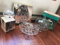 Photo of the full crystal set including candy dish on box, fruit bowl, and cake stand with dome, still boxed.