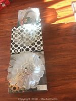 Three clear glass serving ware items laid out vertically: a seashell-shaped platter at top, a round bowl in middle, and a sunflower-shaped platter at bottom.